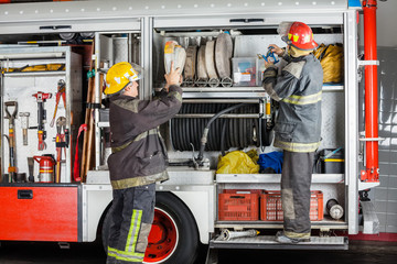 Obraz premium Firemen Working At Truck In Fire Station