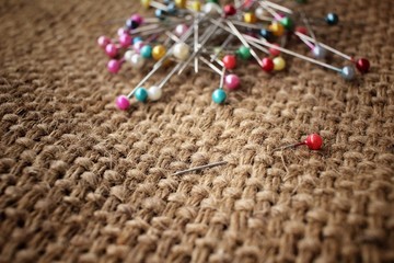 Colorful sewing pins on sackcloth