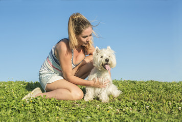 portrait of beautiful girl keeping pretty white West Highland