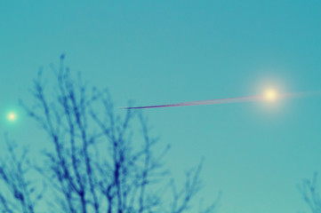 Venus and Jupiter in the sky with a tree silhouette and airplane trail. Taken through my telescope.