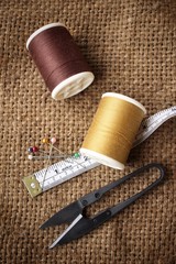 Sewing threads with scissors on sackcloth