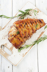 BBQ spare ribs with herbs on a cutting board.