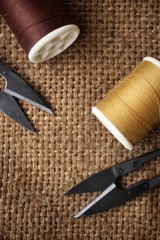 Sewing threads with scissors on sackcloth