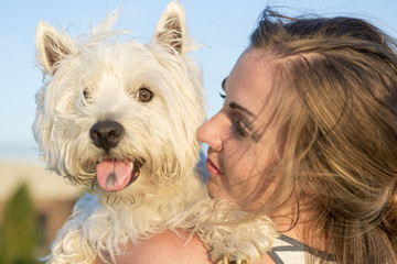 portrait of beautiful girl keeping pretty white West Highland