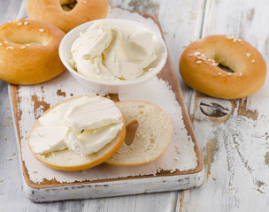 Bagels with cream cheese on  a wooden table.