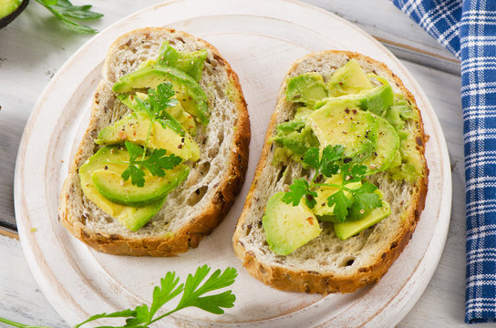 Homemade healthy sandwiches with avocado and fresh herbs.
