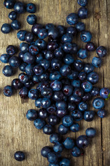 blueberries collected manually scattered on the old board.