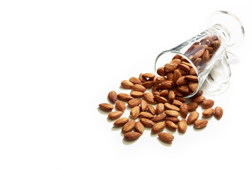 Almonds in the glass and pour on white background, selective focus point