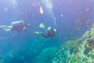 Scuba Diver on coral reef in clear blue water