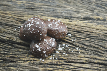 Small chocolate doughnuts on old wooden background