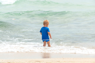 Cute baby boy playing on the beach