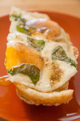 Fried egg with basil on a roll