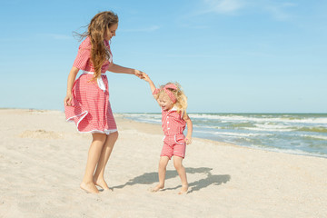Naklejka premium Mother and her daughter having fun on the beach