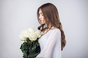 Young girl with a bouquet white roses
