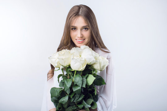 Young girl with a bouquet white roses
