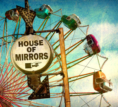 aged and worn vintage photo of house of mirrors sign at carnival