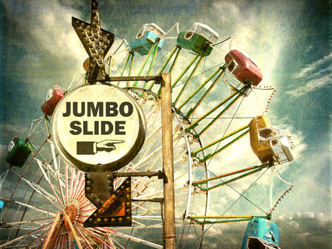 aged and worn vintage photo of jumbo slide ride sign at carnival