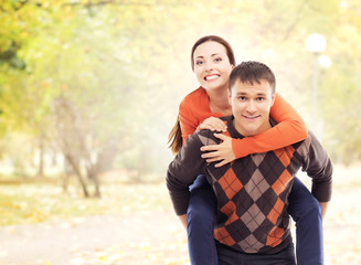 Beautiful and happy couple walking and hugging in the autumn park.