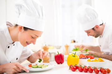 Young attractive professional chef cooking in his kitchen