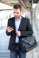 Young attractive business man using smartphone