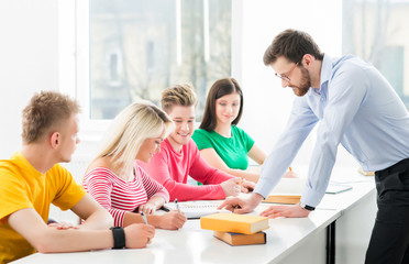 Fototapeta premium Group of teenage students studying at the lesson in the classroom