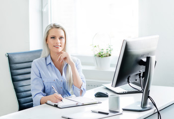 Young, attractive and confident business woman working in office