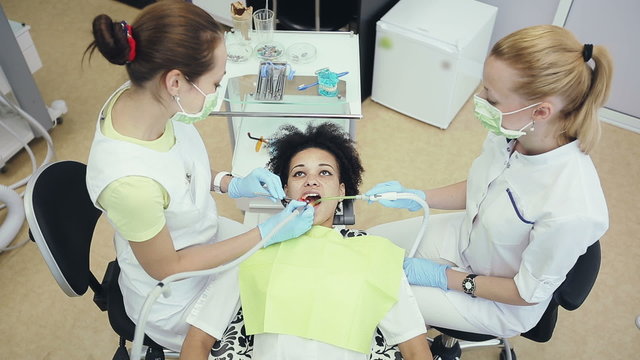 Oral hygiene and dental care: Doctor dentist and assistant working with patient in dental clinic