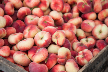 Box of fine ripe flat peaches