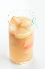 glass of pear juice with cut pieces and straw