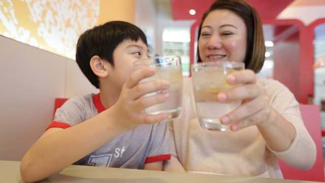 Happy asian mother and her child drinking water, Smile face
