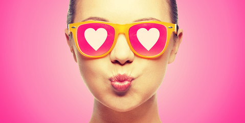 girl in pink sunglasses blowing kiss