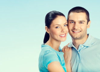 young smiling amorous attractive couple, on blue