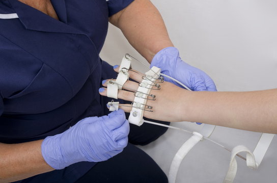 A Teenage Girl With Injured Hand Having A Flexing Splint Fitted By A Nurse