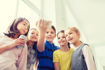 group of school kids with smartphone and soda cans