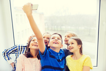 group of school kids taking selfie with smartphone