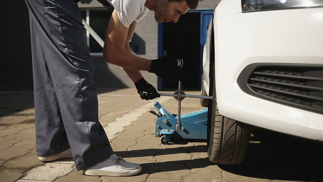 Tire service: Man loosening the screw on a tire