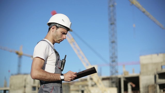 Сonstruction engineer with the tablet pictures of objects on a construction site