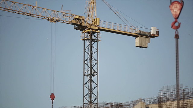 Engineer builder using tablet and walkie talkie, giving instructions at a construction site