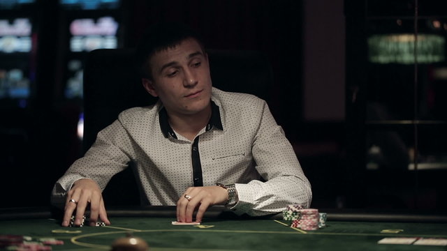 Casino, poker: Man playing poker, check hole cards and doing call