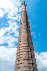 Long old brown smokestack in old factory