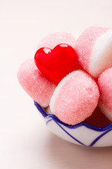 Pink jellies or marshmallows with sugar in bowl