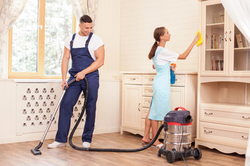 Cheerful young workers are cleaning the house with joy