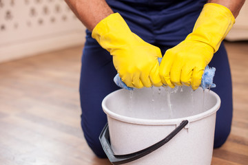 Cheerful young man is doing clean-up in his house