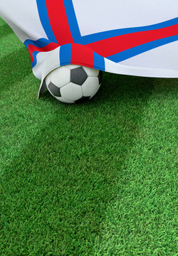Soccer ball and national flag of Faroe Islands,  green grass