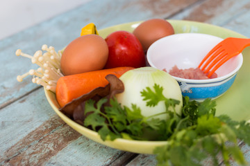 Fresh vegetables, eggs and pork chops. On blue wooden