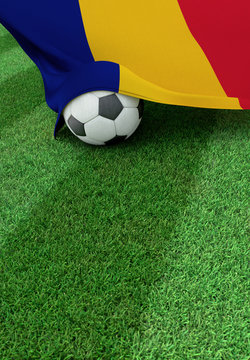 Soccer ball and national flag of Romania,  green grass