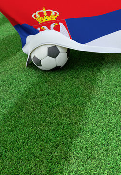 Soccer ball and national flag of Serbia,  green grass