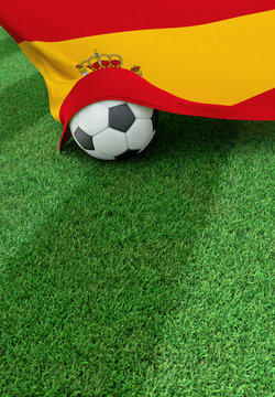 Soccer ball and national flag of Spain,  green grass