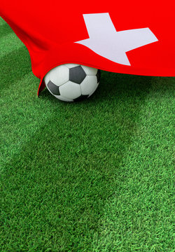 Soccer ball and national flag of Switzerland,  green grass