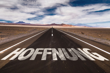 Hope (in German) written on desert road